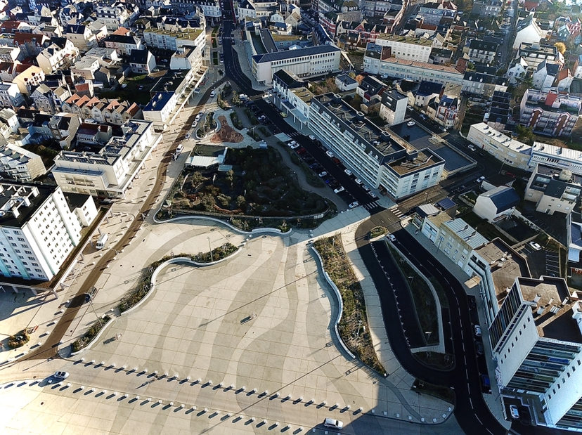 Lavage voiture haute pression : rinçage et mousse Lavage haute pression d'une voiture noire savonneuse sous un ciel bleu, l'eau mousse sur le capot et le pare-chocs.