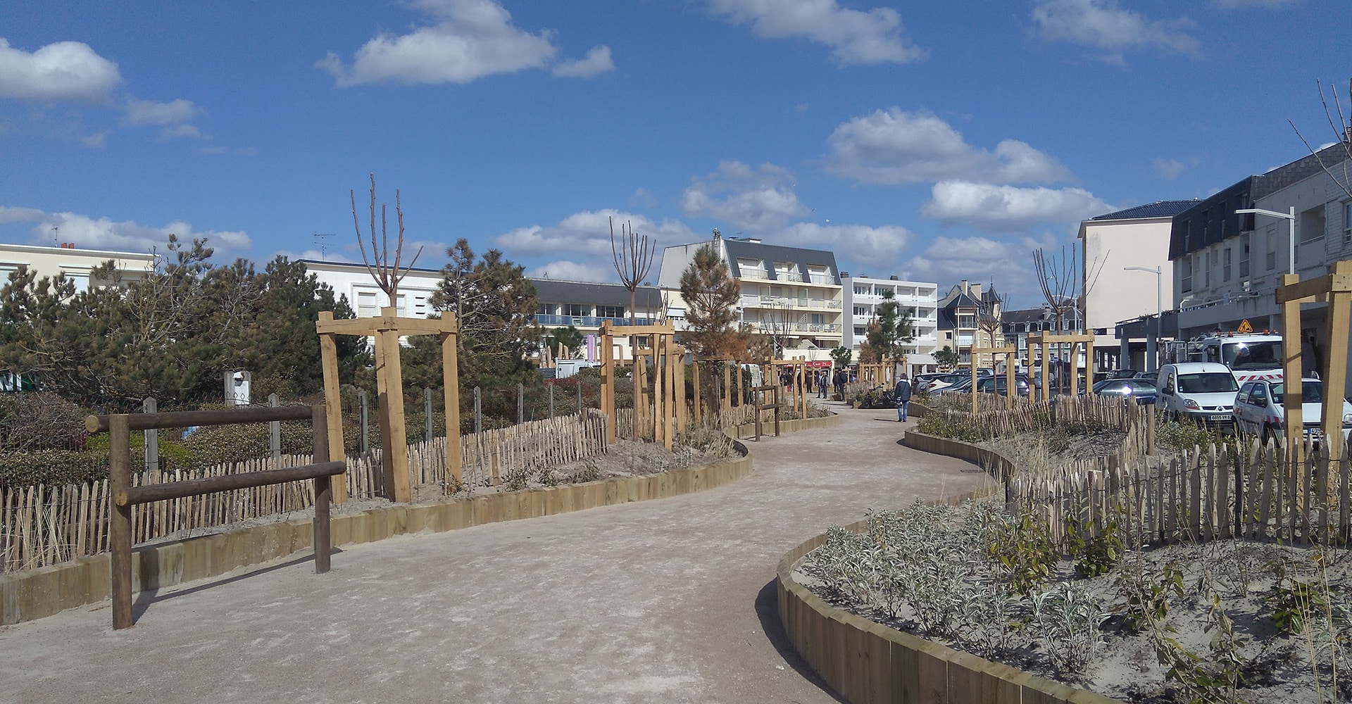 Lavage voiture haute pression : rinçage et mousse Lavage haute pression d'une voiture noire savonneuse sous un ciel bleu, l'eau mousse sur le capot et le pare-chocs.