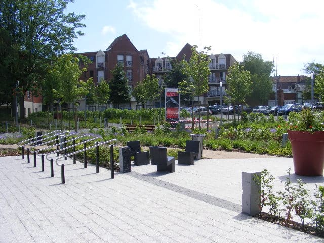 Lavage voiture haute pression : rinçage et mousse Lavage haute pression d'une voiture noire savonneuse sous un ciel bleu, l'eau mousse sur le capot et le pare-chocs.